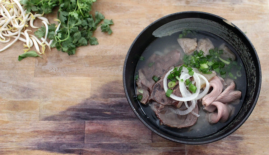 Ladle soup over noodles and meat and top with shallots and onion