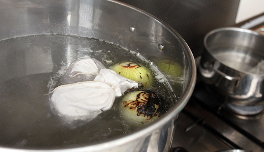 Spice bag and vegetables in stock pot