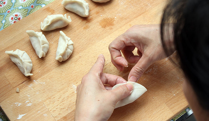 Make one pleat of the dumpling skin (only on one side, leaving the other side unpleated)